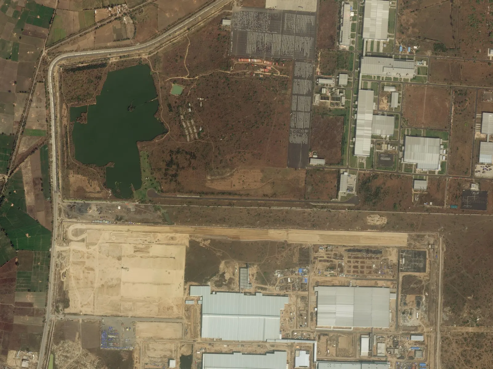 Satellite image of an industrial site in January 2014, with dry scrub around a lake beside the factory